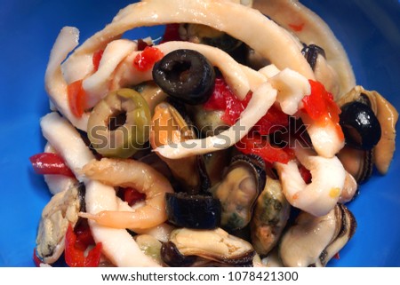 Seafood Salad with Mussels and Squid. Seafood salad with a blue plate on a white background