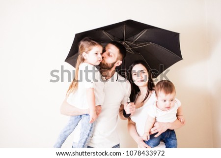 Attractive family standing under umbrella