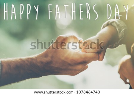 happy father's day text, greeting card concept. father and little son holding hands in sunlight in summer forest. Trust, care and parenting family concept. fathers day. road to life.