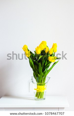 Beautiful yellow tulips flowers in white interior closeup