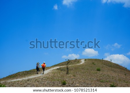 Climbers on the grassy hill. Royalty high-quality free stock image of a group walking up steep grassy hill majestic on a sunny day and blue sky background in summer