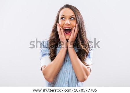 Image of excited businesswoman smiling on the gray background.