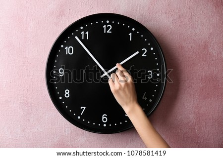 Woman changing time on big wall clock Royalty-Free Stock Photo #1078581419