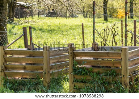 Compost heaps with fertile soil in the green garden Royalty-Free Stock Photo #1078588298