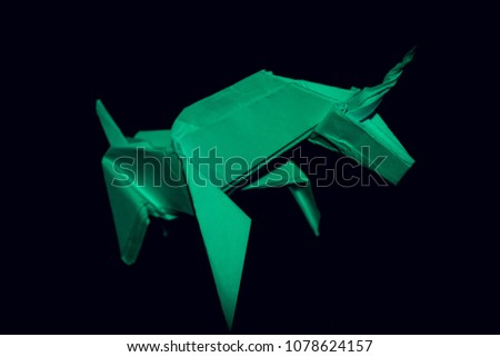 Handmade green unicorn on black background, selective focus, toned