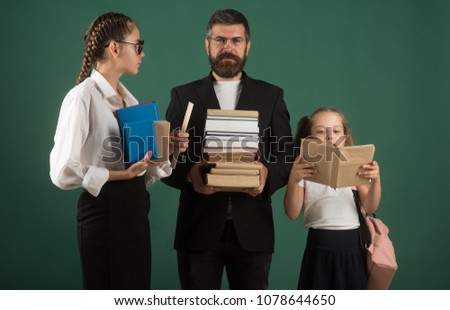 School time of sisters and father in library. Literature lesson and reading grammar book. Education in knowledge day. Teacher man and girls hold book pile at school. Back to school and home schooling.