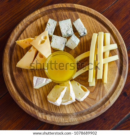 Cheese plate. Assortment of various types of cheese on wooden cutting board