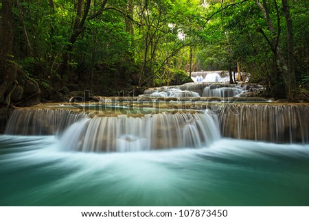 waterfall in thai national park. In the deep forest on mountain. Royalty-Free Stock Photo #107873450