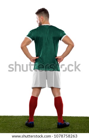 Young soccer player back on grass with green shirt  on white background