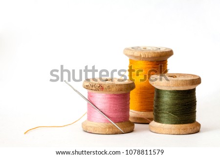 Old wooden coils of thread isolated on a white background.