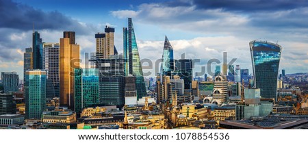 London, England - Panoramic skyline view of Bank and Canary Wharf, central London's leading financial districts with famous skyscrapers at golden hour sunset with blue sky and clouds Royalty-Free Stock Photo #1078854536