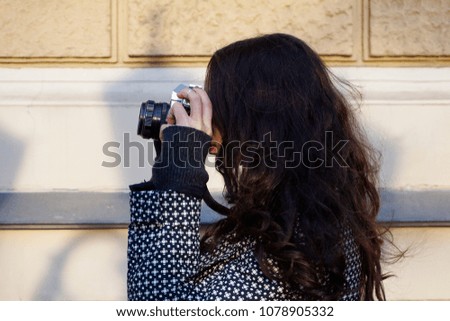  Photographer making pictures by vintage film camera in hipster style. Outdoor summer lifestyle portrait of pretty young woman having fun in the city.