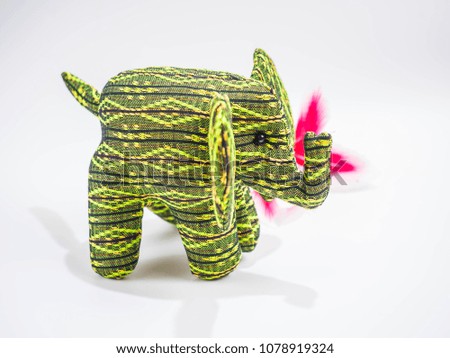 Elephant doll made of green silk material on white background.