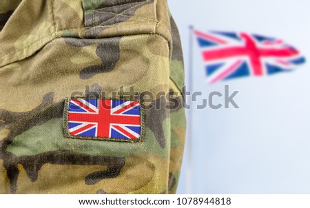 Military man posing in front of UK flag