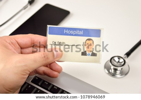 Shot of a hand doctor holding up a identification doctor sign at hospital 