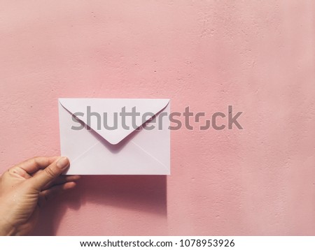Hand hold pink letter at pink wall background