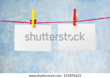 photo paper hanging on the clothesline on light blue background