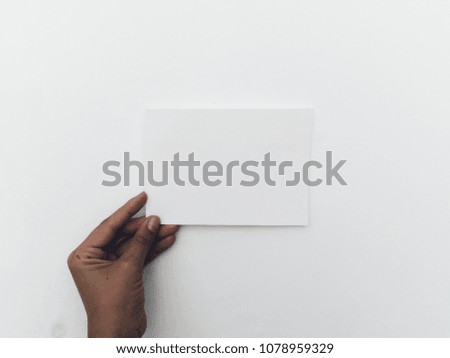 Hand hold white card at white wall background