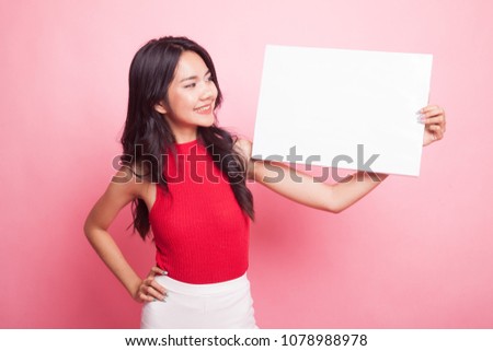 Young Asian woman with white blank sign on pink background