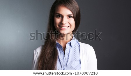 Portrait of a businesswoman , against dark background. Woman smi