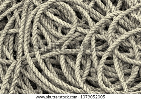 Closeup of a coil of old hemp rope. A high contrast monochrome edit. 