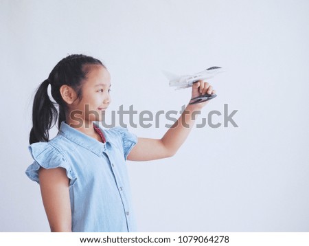 Happy Asian girl holding airplane model in hand.