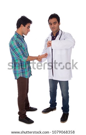 Full-length shot of twins one of them a doctor and he is checking his brother heartbeats, isolated on white background