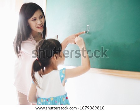 Teacher teaching student in the class.