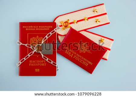 Foreign passport of  Russian citizen and  police officer's certificate locked in  chain with  lock. Anti-Russian sanctions.
