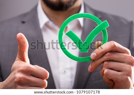Close-up Of A Businessperson's Hand Holding Green Check Mark Icon Royalty-Free Stock Photo #1079107178