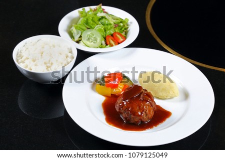 Japanese style hamberger serve with gravy sauce, potato, vegetables salad and rice