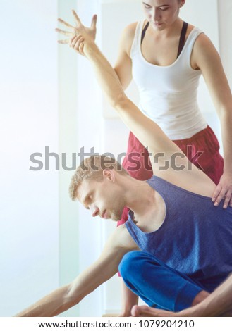 Young healthy couple in yoga position on white background