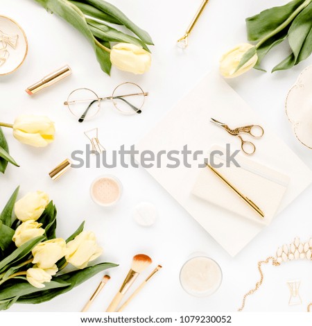 Female workspace with yellow tulip flowers, women's golden accessories, diary,  glasses on white background. Flat lay. Top view feminine background.
