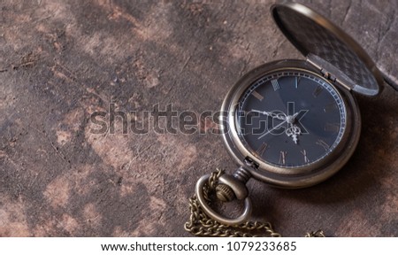 Old pocket watch on wooden table top