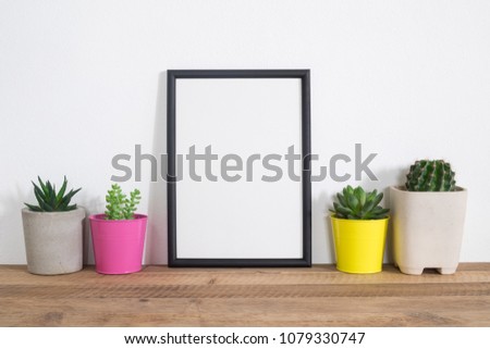 Succulents plant and  blank frame poster on table.trendy houseplant with home decoration