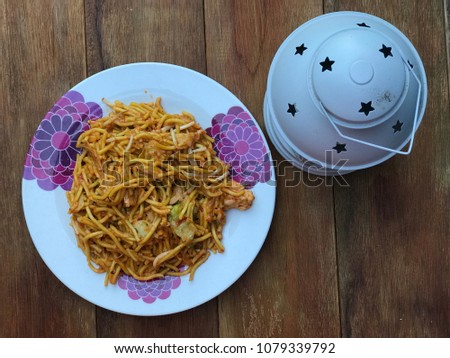 Malaysian style fried noodle or local tongue call mee goreng with lantern on wooden table