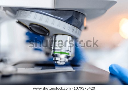 Medical laboratory. Scientist hands using microscope for chemistry biology test samples,examining liquid, equipment. Scientific and healthcare research background.