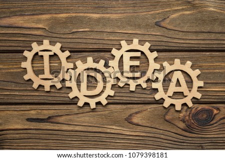 word IDEA from the gears of the parts of the puzzle. Business concept. Innovations, cooperation, teamwork. Strategy, creative. Copy space for text design. From natural wood, on a blue background