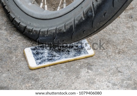 Smartphone display smashed by wheel motorcycle on floor road background. Close Up, selective focus