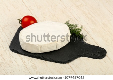 Camembert cheese over the wooden background