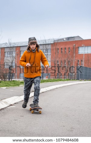 Young boy's first steps on skate. Practicing skating on empty street. Balance concept