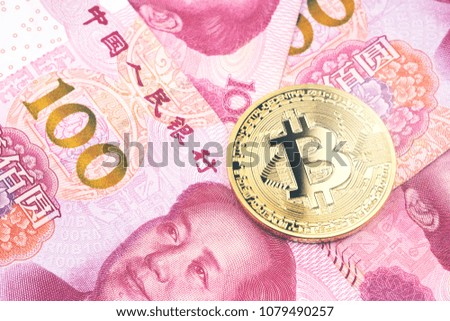 Golden bitcoin on pile of one hundred Chinese yuan banknotes background. Cryptocurrency, digital currency with yuan money bills.