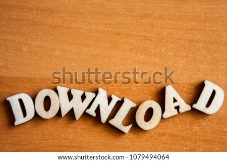The word 'download' made of wooden letters. wood inscription on table
