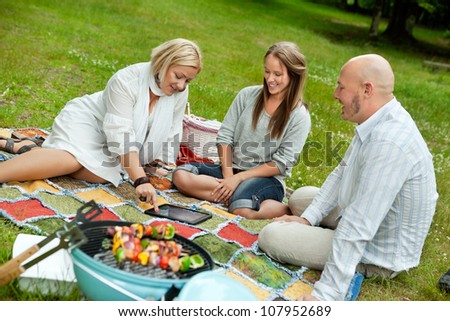 Group of friends looking at pictures outdoors in park