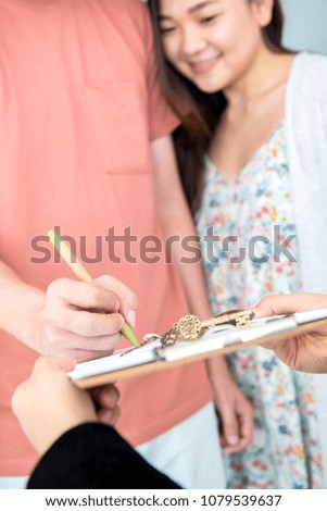 Couple buy a new home. Sign contact and get a key.