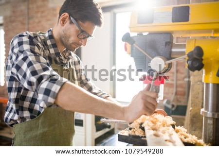 Waist up portrait of handsome man using machines while working  with wood in carpenters shop, copy space