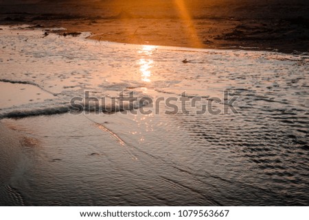 sunset over a tide pool on the beach