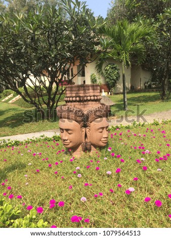 Resort road sign in beautiful grass background / Buddha face in green grass resort / Resort in asia 