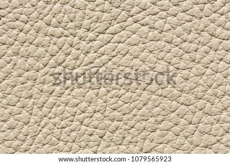 Beige leather texture with uneven surface. High resolution photo.