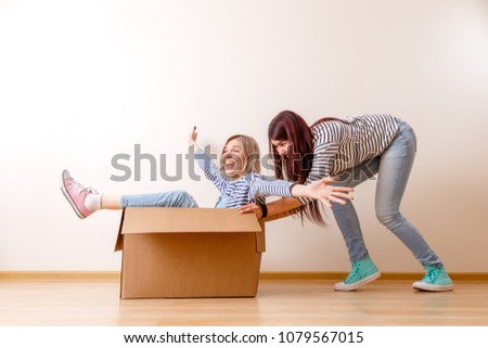 Photo of blonde in cardboard box and brunette